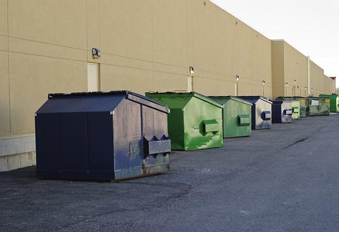 a series of colorful, utilitarian dumpsters deployed in a construction site in Barrington NH